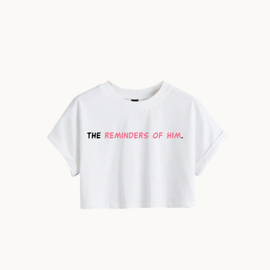 "White cropped t-shirt with the text 'THE REMINDERS OF HIM.' in bold black and pink font. - SKULLMASK